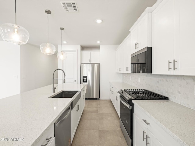 4032 S 176th Dr, Goodyear, AZ 85338 - kitchen featuring stainless steel appliances, backsplash, recessed lighting, light stone counters, and white cabinets