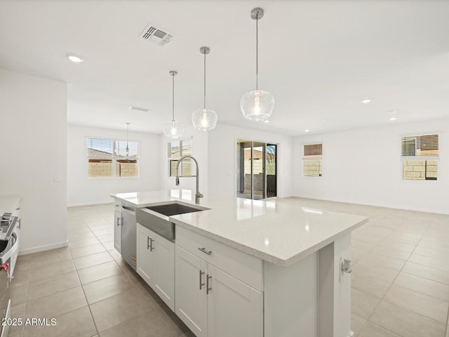 4032 S 176th Dr, Goodyear, AZ 85338 - kitchen featuring dishwasher, an island with sink, light stone counters, light tile patterned floors, and open floor plan