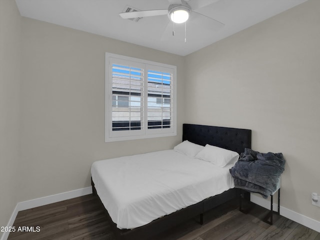 bedroom featuring ceiling fan, visible vents, baseboards, and wood finished floors