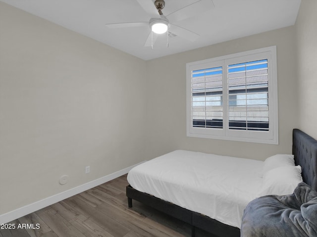 bedroom featuring ceiling fan, wood finished floors, and baseboards