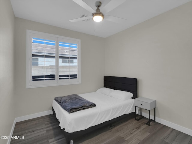 bedroom featuring ceiling fan, baseboards, and wood finished floors