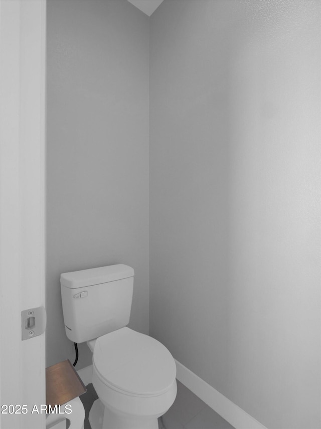 bathroom featuring toilet and baseboards