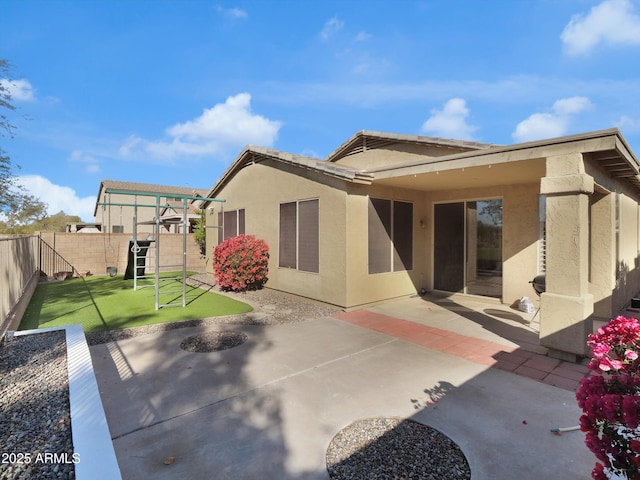 back of property featuring a patio, a yard, a fenced backyard, and stucco siding