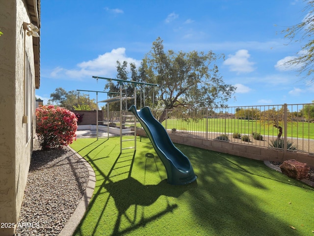 view of jungle gym with a fenced backyard and a yard