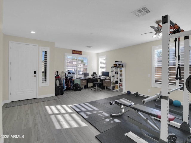 exercise area featuring baseboards, visible vents, wood finished floors, and recessed lighting