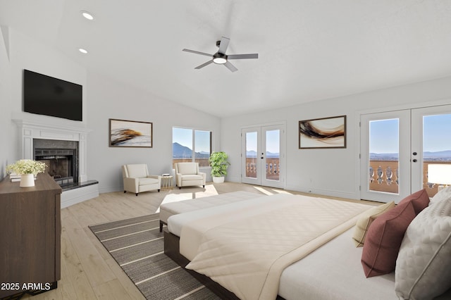 bedroom featuring french doors, lofted ceiling, a fireplace, and access to outside