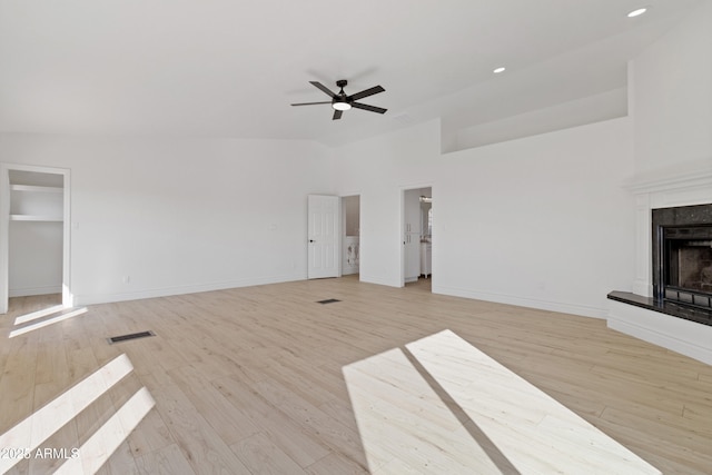 unfurnished living room with light hardwood / wood-style flooring, a high end fireplace, and ceiling fan