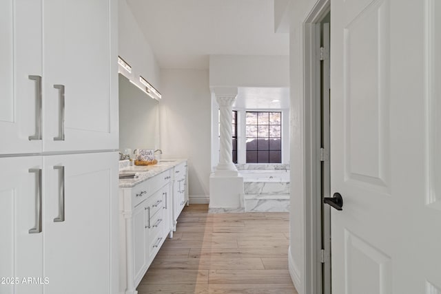 bathroom with vanity, hardwood / wood-style floors, and ornate columns