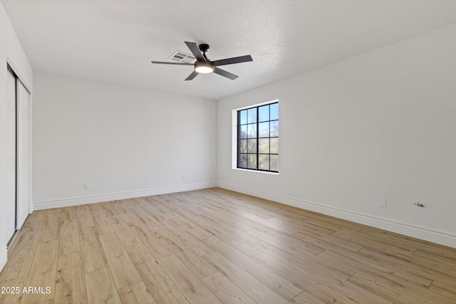 unfurnished bedroom featuring ceiling fan, a textured ceiling, light hardwood / wood-style floors, and a closet