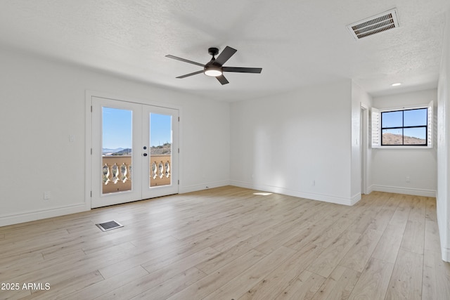 spare room with french doors, ceiling fan, a textured ceiling, and light hardwood / wood-style flooring