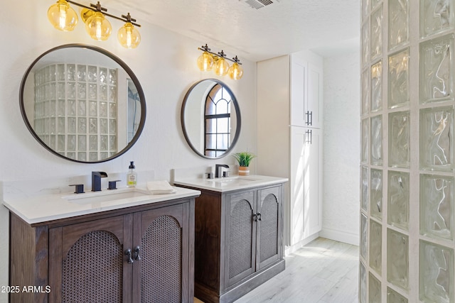 bathroom with vanity, hardwood / wood-style flooring, and a textured ceiling