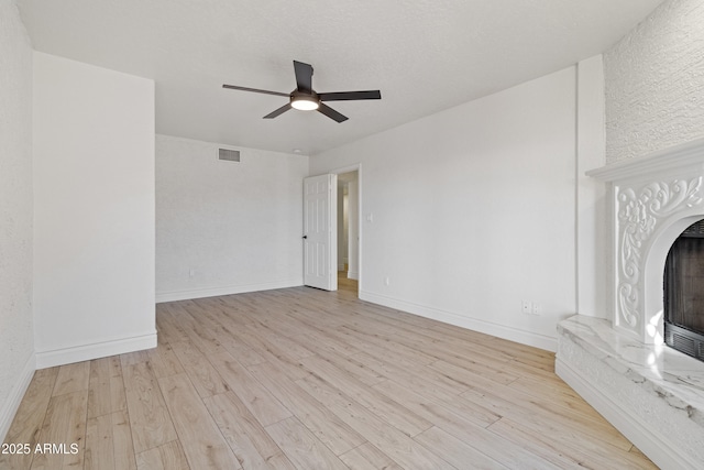 unfurnished living room with ceiling fan and light hardwood / wood-style floors