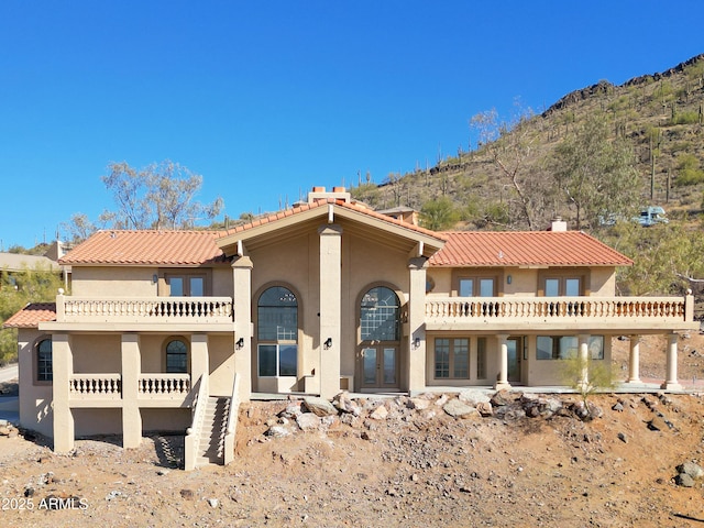 view of front of house with a mountain view and a balcony