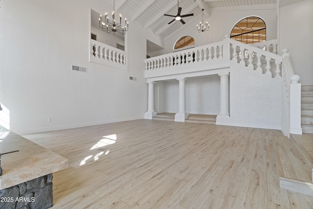 unfurnished living room with wood ceiling, light hardwood / wood-style flooring, high vaulted ceiling, ceiling fan with notable chandelier, and beamed ceiling