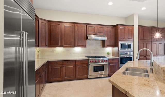 17755 E Colt Dr, Queen Creek, AZ 85142 - kitchen with under cabinet range hood, pendant lighting, decorative backsplash, high end appliances, and a sink