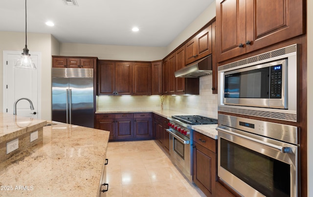 17755 E Colt Dr, Queen Creek, AZ 85142 - kitchen with under cabinet range hood, light stone counters, light tile patterned flooring, decorative backsplash, and built in appliances