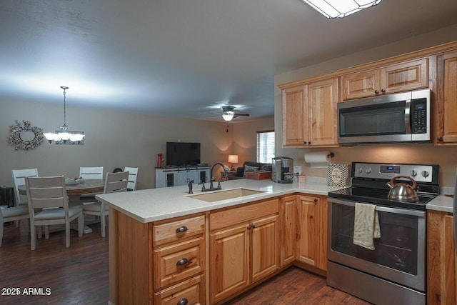 1449 Elk Dr, Forest Lakes, AZ 85931 - kitchen with sink, hanging light fixtures, kitchen peninsula, stainless steel appliances, and dark wood-type flooring