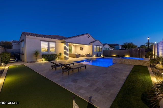 pool at twilight featuring a patio area and an outdoor hangout area