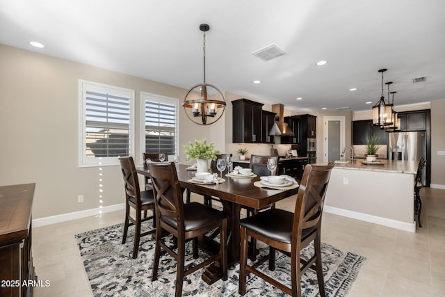 dining room featuring an inviting chandelier, light tile patterned floors, and sink