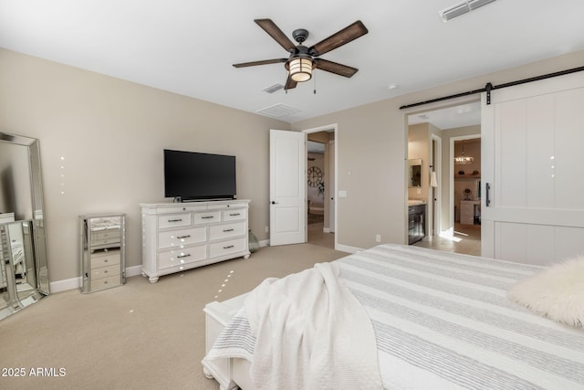 carpeted bedroom with ensuite bathroom, ceiling fan, and a barn door