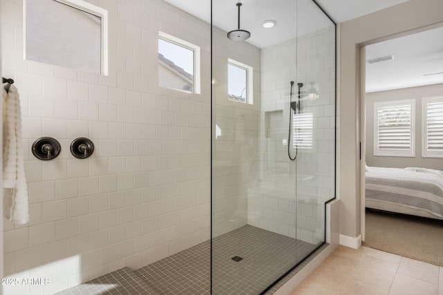 bathroom with tile patterned flooring and a tile shower