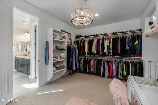 spacious closet featuring light colored carpet, a chandelier, and sink