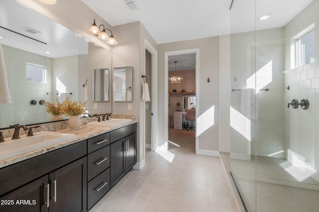 bathroom featuring a tile shower, vanity, tile patterned floors, and a wealth of natural light