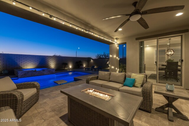 patio terrace at dusk featuring an outdoor living space with a fire pit and a swimming pool with hot tub