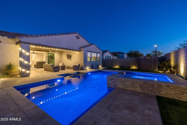 pool at twilight featuring a patio, an in ground hot tub, and outdoor lounge area