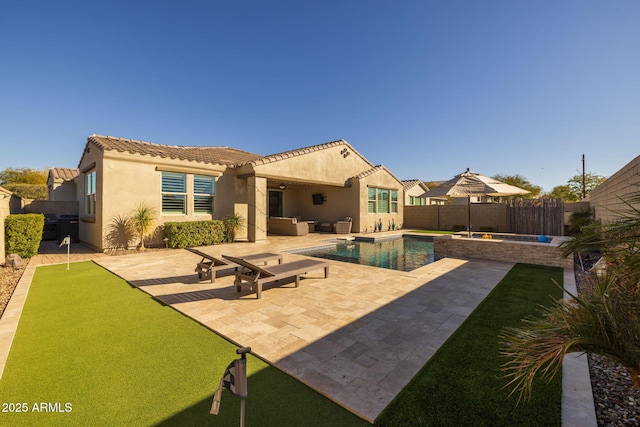 rear view of property with a fenced in pool, outdoor lounge area, and a patio