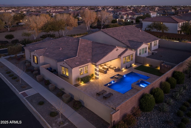 pool at dusk featuring a patio