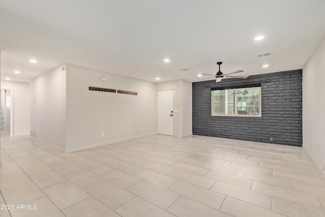 unfurnished room featuring recessed lighting, visible vents, ceiling fan, brick wall, and baseboards