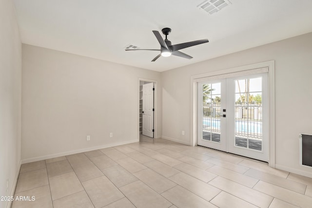 empty room with french doors, visible vents, light tile patterned flooring, ceiling fan, and baseboards