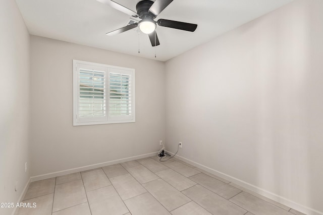 spare room featuring light tile patterned floors, a ceiling fan, and baseboards