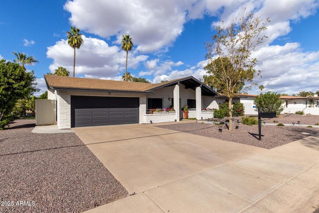 view of front of house with a garage, brick siding, and driveway