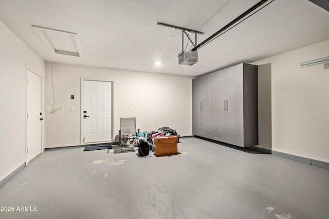 garage with a garage door opener and baseboards