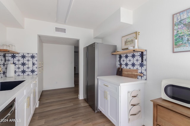 kitchen with dark wood-type flooring, sink, appliances with stainless steel finishes, tasteful backsplash, and white cabinetry