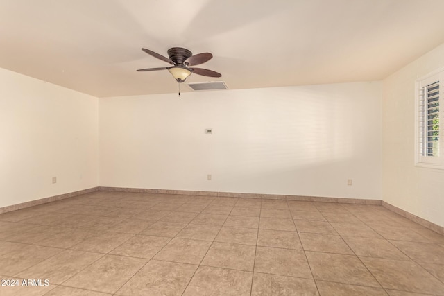 tiled spare room featuring ceiling fan