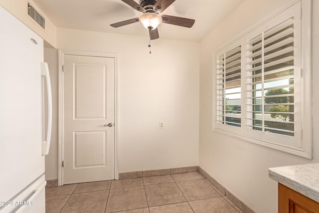 unfurnished room with ceiling fan and light tile patterned flooring