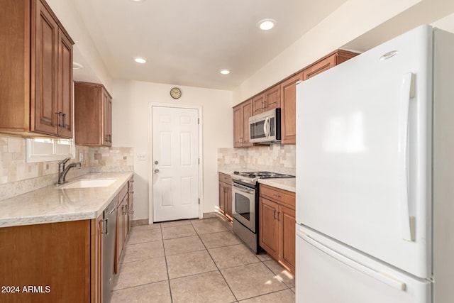 kitchen with tasteful backsplash, sink, light tile patterned floors, and stainless steel appliances