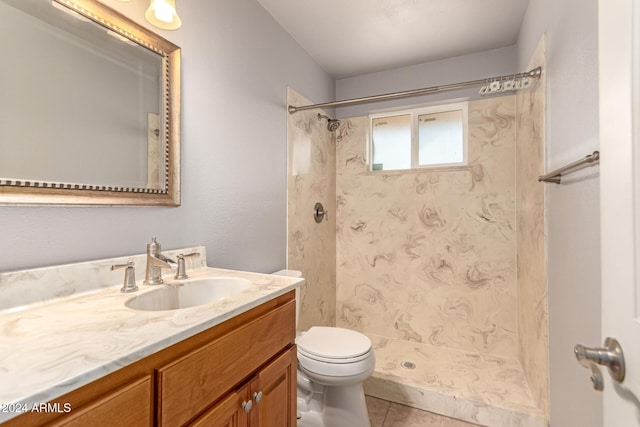 bathroom featuring a shower, vanity, toilet, and tile patterned flooring