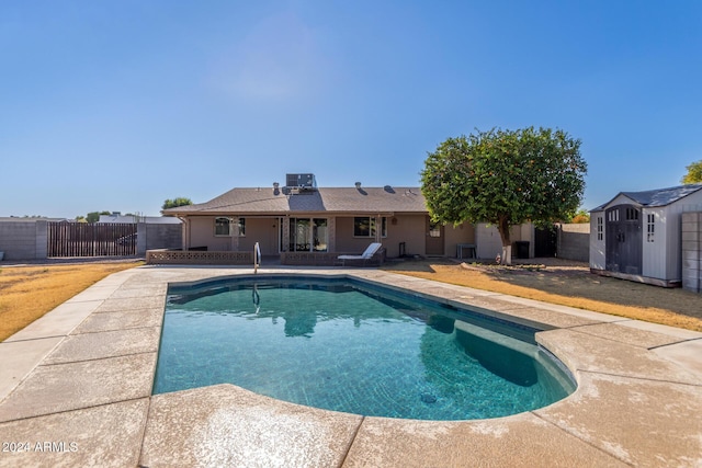 view of swimming pool with a shed, a patio area, and central air condition unit