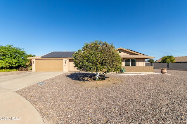 view of front of property with solar panels and a garage