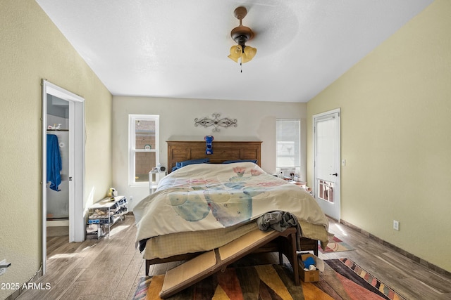 bedroom featuring lofted ceiling, hardwood / wood-style floors, ensuite bath, and ceiling fan