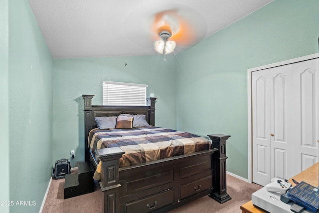 bedroom featuring vaulted ceiling, light carpet, ceiling fan, and a closet