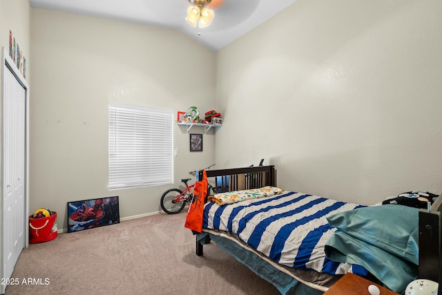 bedroom with ceiling fan, carpet flooring, vaulted ceiling, and a closet