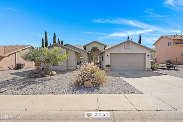 single story home with a garage and central AC unit