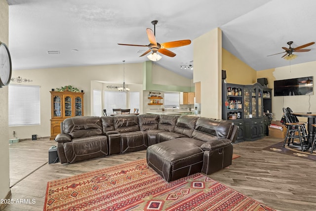 living room with lofted ceiling, hardwood / wood-style floors, and ceiling fan with notable chandelier