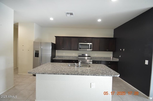 24646 N Barley Rd, Florence, AZ 85132 - kitchen featuring stainless steel appliances, light tile patterned floors, light stone countertops, a sink, and dark brown cabinets