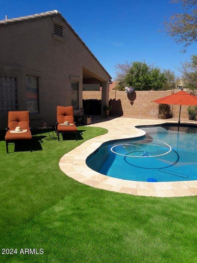 view of pool featuring a lawn and a patio